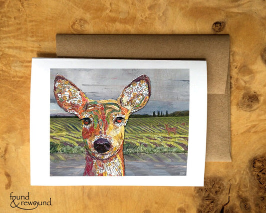 Greeting Card of a Paper Collage of a deer face close up with others browsing in the rain behind - Blank Inside